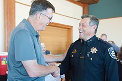 PHOTO BY MARK MCKENNA - Former EPD Chief David Douglas and outgoing Chief Andrew Mills chat at Mills' farewell reception at the Wharfinger Building.