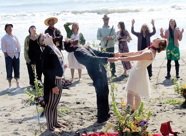 Willoughby and Isabelle Arevalo hold hands and look to the sky as family, friends and a clown named Elliot join them to celebrate their wedding vows on Saturday, March 22 at College Cove Beach. - PHOTOS BY BOB DORAN
