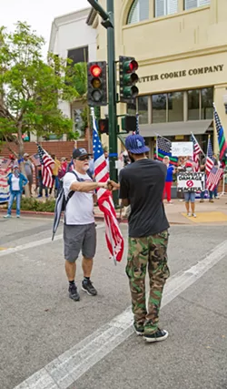 RECONCILING A Black Lives Matter protester fist bumps with a counterprotester on Aug. 25 after discussing why they believe what they do about the movement. - PHOTO BY JAYSON MELLOM
