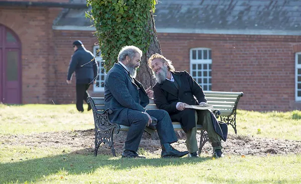 WORD HOUNDS Based on the true story of the creation of the Oxford English Dictionary, project leader and autodidact James Murray (Mel Gibson, left) enlists murderer and asylum patient Dr. William Chester Minor (Sean Penn) to compile etymological entries of every word in the English language, in The Professor and the Madman, available on Netflix. - PHOTO COURTESY OF VOLTAGE PICTURES