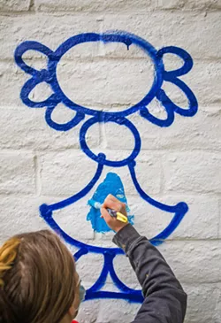 DETAIL Student artist Celeste Dowlan fills in shapes in Juan Alberto Negroni's mural, which tries "to translate into a visual language what it means to come from Puerto Rico," he said. The mural will remain in place for one year, after which it will be replaced by another artist's mural. - PHOTO BY JAYSON MELLOM