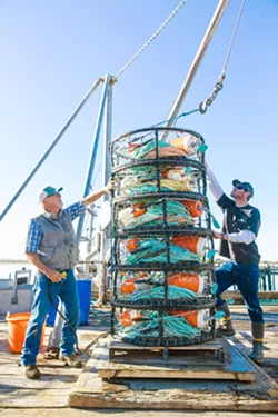 CHANGING SEASON Fisherman Bill Blue (left) and his crew member Bud Hurless (right) secure crab pots as they wait for the start of the season. - PHOTO BY JAYSON MELLOM