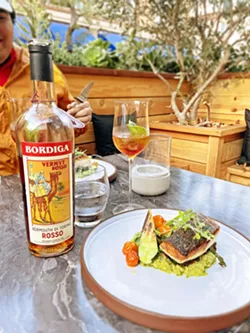 AFTER AN ITALIAN APERITIF Chef Brendan Collins' seasonal creations capitalize on local ingredients, such as sea bass with crushed zucchini, roasted summer squash, and blistered cherry tomatoes. - PHOTO BY CHERISH WHYTE