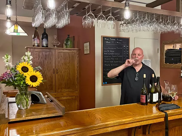 THE PERFECT POUR Store manager Tom Nicholas samples wares at CCW's intimate, 15-seat tasting room. Patrons can order a flight, glass, or bottle of wine, as well as draft or bottled beer. - PHOTO BY CHERISH WHYTE