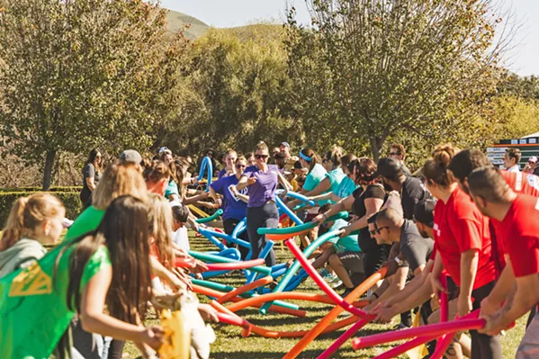 DOWN THE AISLE Wedding Games teams battle to see who can run down the aisle fastest while being hit by pool noodles. The annual event is indicative of how the local wedding industry is defined by a motto of "community over competition." - PHOTO COURTESY OF PATRICK ANG