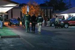 BAD BOYS, BAD BOYS : Sheriff’s deputies and probation officers took an unidentified man into custody at a Paso Robles motel as part of a sweeping anti-narcotics operation headed by the FBI. Faces have been blurred at the request of law enforcement for the safety of the narcotics officers. - PHOTO BY STEVE E. MILLER