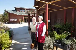REASON TO SMILE : SLO Botanical Garden Development Director Liz Scott Graham and architect Ken Haggard, who designed the garden’s self-sustaining buildings in the background, muse about the dramatic expansion planned for the site.**** - PHOTO BY STEVE E. MILLER
