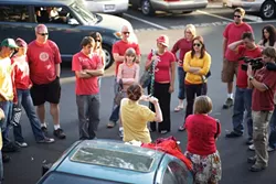 T-SHIRT FLASH MOB : More than two dozen people assembled in the New Times parking lot on Aug. 20 to prepare for a flash mob that involved taking off their shirts at Farmer’s Market. - PHOTO BY STEVE E. MILLER