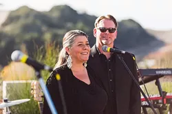 THE MAN (AND WOMAN) IN BLACK: Central Coast LIVE! founders Jennifer and Brad Golden welcome local musicians and dedicated fans during the Dec. 5 launch party for their company’s new livestream music radio app, which features exclusively local musicians. - PHOTO COURTESY OF JP SAWYER OF JOHN PATRICK IMAGES