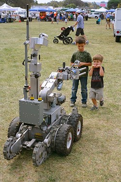 BOMB BOT:  Two young boys get up close and personal with a robot designed to remotely defuse bombs. - PHOTO BY GLEN STARKEY
