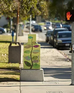 ORNAMENTAL, AS WELL AS USEFUL: Aaron Landrith, a senior architecture student, discusses the city's role in curating artistic taste through its commissioning of painted utility boxes, such as this one by local artist Marcia Harvey. - PHOTO BY STEVE E. MILLER
