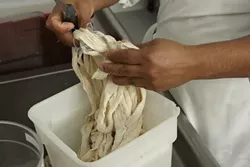 16: : After mixing for a set amount of time, the batch of salami meat will be transferred to the stuffing machine that feeds the meat into its casing.