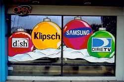 BRANDED BULBS: Though it is a creative discipline, window painting is primarily used for advertisement. Here, Loney incorporates brand names into a seasonal scene. - PHOTO COURTESY OF MIKE LONEY