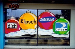 BRANDED BULBS:  Though it is a creative discipline, window painting is primarily used for advertisement. Here, Loney incorporates brand names into a seasonal scene. - PHOTO COURTESY OF MIKE LONEY