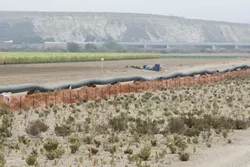 THAT’S A BIG PIPE: The steel-cased pipeline was welded and pressure tested prior to being dragged through the hole under the riverbed. - PHOTO BY STEVE E. MILLER