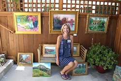 OPEN AIR: Christine Cortese sits with her oil paintings in the driveway of fellow artist for Art Obispo’s Open Studios Art Tour 2015. - PHOTO BY REBECCA LUCAS