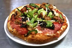 HOME SLICE: A personal pizza you won’t want to share? Try Gino’s personal pizza topped with sausage, peppers, and bubbly mozzarella cheese. - PHOTO BY DYLAN HONEA-BAUMANN