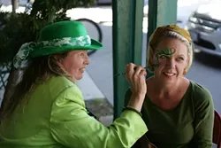 GET YOUR SPIRIT ON: Longtime face painter Teresa Schmidt (481-5093) set up shop in front of McCarthy’s Irish Pub, here painting Laurel White. - PHOTO BY GLEN STARKEY