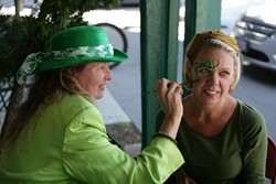 GET YOUR SPIRIT ON:  Longtime face painter Teresa Schmidt (481-5093) set up shop in front of McCarthy&rsquo;s Irish Pub, here painting Laurel White. - PHOTO BY GLEN STARKEY