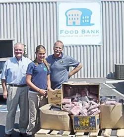 SUSTENANCE : Volunteer Christine Allen, Food Bank Executive Director Carl Hansen (left), and Food Bank Warehouse Manager Stan Schecter coordinate the distribution of high-protein meals thanks to donations arranged through 4-H. - PHOTO BY DEBBIE ALLEN