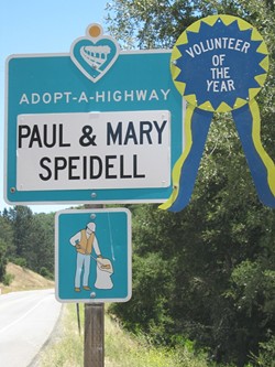 SIGN OF THEIR TIME:  Paul and Mary Speidell were honored in 2011 by Caltrans with this ribbon placed on their road sign, recognizing their 25 years of picking up litter - on Highway 46 West. - PHOTO COURTESY OF CALTRANS
