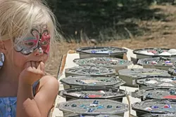 KIDS’ CRAFTS : A little girl checked out the crafts drying on a table.