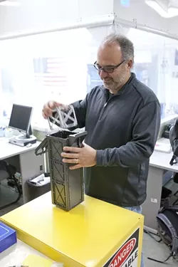 SATELLITE SHRINKER: Dr. Jordi Puig-Suari, an aerospace engineering professor, demonstrates the Cal Poly-created CubeSat technology—miniature satellites packed with increasingly complex data-recording equipment. - PHOTO BY STEVE E. MILLER