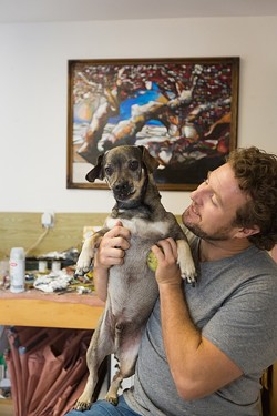 MAN&rsquo;S BEST FRIEND:  Jordan Quintero hangs out with his dog, Beckman, at his studio in Arroyo Grande. Note: Quintero is the one on the right. - PHOTO BY KAORI FUNAHASHI