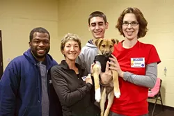 DOG LOVERS: Woods Humane Society staff members (left to right) Chris Williams (customer service manager), Michelle Rizzi (behavioral trainer and manager), Eric Stockam (animal caregiver), and Chelsea Mills (master trainer and volunteer) are deeply devoted to the animals they care for. - PHOTO BY GLEN STARKEY