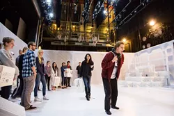 FOLLOW THE LEADER: In 'The Other Shore,' the audiences becomes a part of the play. Before the play begins, they’re led to the stage and can pick portable seating (white crates) that move throughout the show. - PHOTO BY KAORI FUNAHASHI