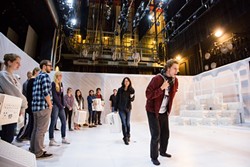 FOLLOW THE LEADER:  In 'The Other Shore,' the audiences becomes a part of the play. Before the play begins, they&rsquo;re led to the stage and can pick portable seating (white crates) that move throughout the show. - PHOTO BY KAORI FUNAHASHI