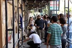 GUERILLA ART SHOW : On June 14, the New Arts Collective hosted the Guerrilla Art Show at a construction site in downtown SLO; the effort was spearheaded by NAC member Neal Breton (the guy in the cap, carrying - PHOTO BY STEVE E. MILLER