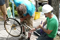 TAG TEAM: Tall Bike Posse members Tom Smith and Bill Mulder make quick work of a bike frame during the Bike Build on April 18. - PHOTO BY GLEN STARKEY