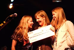 ALL SMILES : (Left to right) Downtown Brew’s Korie Newman, Arts Obispo’s Programs Manager Alissa Maddren, and AmeriCorp volunteer coordinator at Arts Obispo Jamie Dietze hold a check for $1,000. - PHOTO BY STEVE E. MILLER