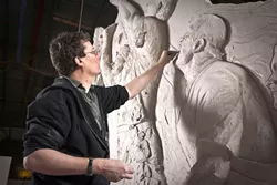 BEFORE AND AFTER : Richard Taylor, creative director of Weta Workshop, is pictured at work on the Rugby World Cup sculpture (left) and next to the finished product. “I still spend about 80 percent of my workday down on the workshop floor, working with our team,” explained Taylor. “I got into this business to make cool stuff, and I never want to imagine that I foolishly put myself in a place where I’m so busy managing the cool stuff that I don’t get to make it. I take great delight in being very hands-on.” - PHOTO BY STEVE UNWIN