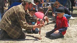 WAY OLD SCHOOL : Counselor Sam McRee of Outside Now taught a group of boys how to start a fire with nothing but a few sticks and a piece of string. - PHOTO BY NICK POWELL