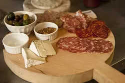 MEAT AND CHEESE : Cutting boards covered in salami, cheese, and olives are one option for a light lunch.