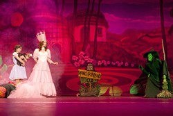 'WHERE TROUBLES MELT LIKE LEMON DROPS':  Dorothy (Cassie Johnson; left) finds herself in Munchkinland with Glinda the Good Witch (Allison King; pink gown), but is soon confronted by Glinda&rsquo;s nemesis, the Wicked Witch of the West (Theresa Riforgiate; green face), in Kelrik&rsquo;s 'The Wizard of Oz.' - PHOTO BY STEVE E. MILLER