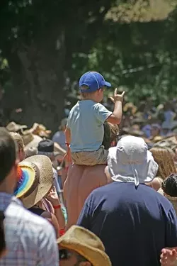 THE LITTLEST ROCKER: A kid gets into the spirit atop the shoulders of his dad.
