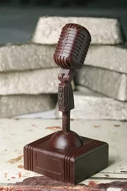 Finished wax piece with examples of bronze ingots in the background. - PHOTO BY STEVE E. MILLER