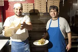 FLYING FOOD : Roberto Zillante (left) tosses fresh pizza dough and Ciro D’Onofrio (right) showcases one of the many Italian sandwiches available at this new pizzeria. - PHOTO BY STEVE E. MILLER
