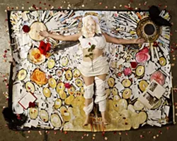 SMILE! : Painter Josephine Crawford lies inside the outline of herself in her mixed media art piece The Big Bang. Artist Lena Rushing created the disturbingly accurate portrait on her face. - PHOTO BY STEVE E. MILLER