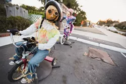 RIDE ALONG: One of the most popular scarecrow installations in town features a working bicycle with two straw-stuffed riders atop. - PHOTO BY KAORI FUNAHASHI