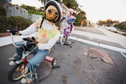 RIDE ALONG:  One of the most popular scarecrow installations in town features a working bicycle with two straw-stuffed riders atop. - PHOTO BY KAORI FUNAHASHI