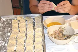 FAMILY FLAVOR: Oki Momo Asian Grill’s pork and shrimp wantons are made by hand, just like they have always been made in owner/brothers David and Jonathan Yeh’s family. The morsels are stuffed with baby bok choy, water chestnuts, and onion, and served with housemade ginger soy dipping sauce. - PHOTO BY HAYLEY THOMAS