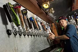 LIBERATE THE FLAVOR : Bar manager Tyler Clark keeps 20 taps connected to a rotating supply of the world’s best beers at the newly opened Libertine Pub, 801 Embarcadero Road. - PHOTO BY STEVE E. MILLER