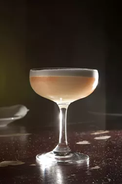 TWO DOLPHINS KISSING!: Everybody sees something different in the head of the frothy Abstract Art, but it’s consistently a floral blend of gin, bitters, egg whites, and lemon. Think of it as a tasty Lemon Julius. - PHOTO BY STEVE E. MILLER