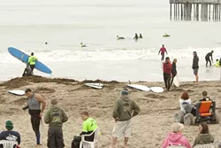 SOLDIERING ON : Surf instructors, wounded soldiers, volunteers, and spectators are on hand at Cayucos Pier, one of several locations for Operation Surf, a rehabilitation retreat for vets. - PHOTOS BY STEVE E. MILLER