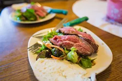 STAR SALAD: Tri-tip marinated in ginger, garlic, soy sauce, and olive oil is sliced over red-leaf butter lettuce, green leaf, and radicchio. A sprinkling of goat cheese, avocado, Kalamata olives, walnuts, balsamic vinaigrette, and a mighty crank of black pepper finish the simple dish. - PHOTO BY KAORI FUNAHASHI