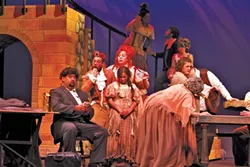 MASTER OF THE HOUSE: Nik Johnson (center, hand in mouth) and Robin Kirk Wolf (red hair) play the crooked Madame and Monsieur Thénardier in Chameleon Productions’ Les Miserables. - PHOTO BY AUDREY HOWARD